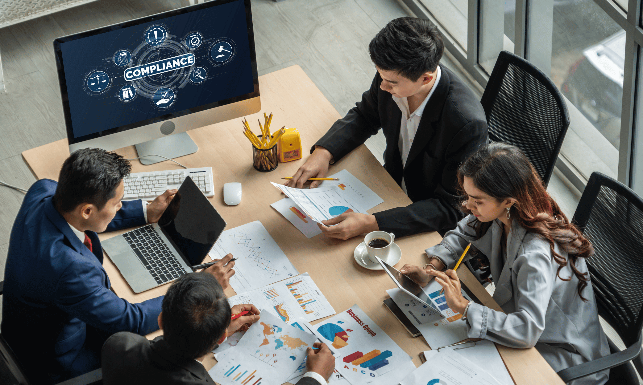 Four people sitting around a table looking at charts