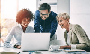 Business people, laptop and meeting in planning, teamwork or coaching for project on bokeh background at office. Group of happy employees working on computer for schedule plan, ideas or team strategy.