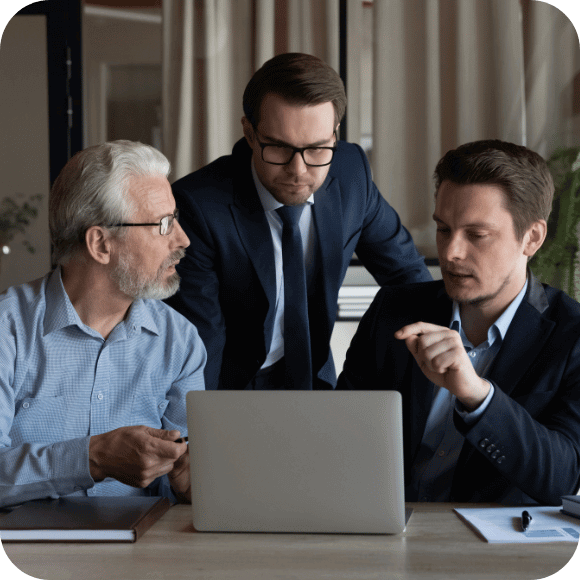 Three people looking at a computer.